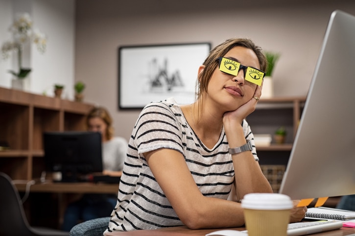 Women feels tried after a concussion. Puts post-it notes over eye to look awake.