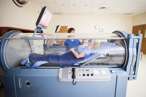 Client laying in hyperbaric oxygen chamber