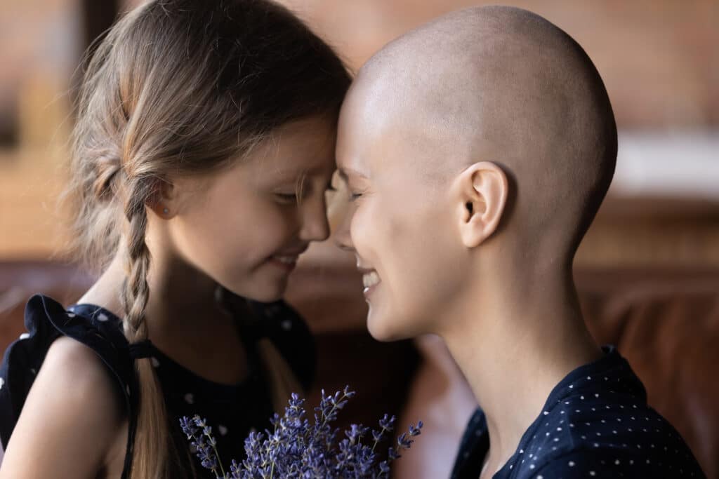 Happy grateful mom with cancer and sweet little daughter kid